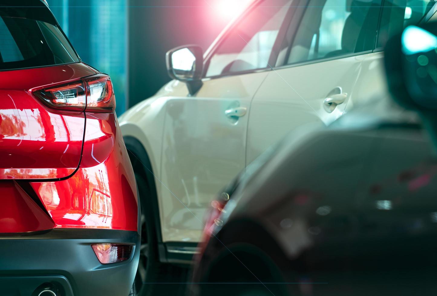 primer coche suv de lujo con diseño deportivo estacionado en una moderna sala de exposición. vista trasera del coche todoterreno rojo brillante en la sala de exposición. concepto de concesionario de automóviles. industria automotriz. negocio y tecnología de automóviles eléctricos. foto