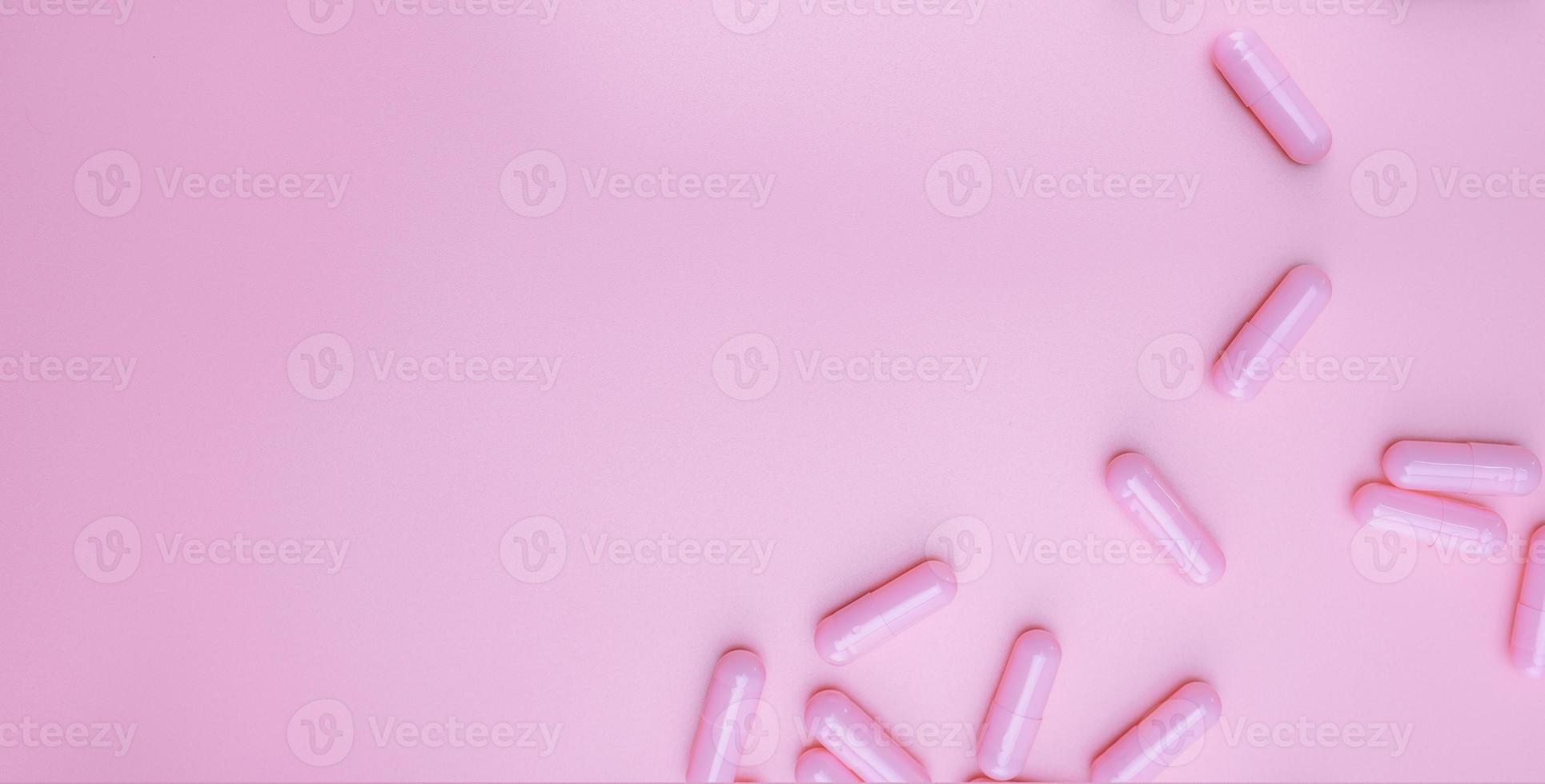 vista superior cápsulas de color rosa píldora sobre fondo de color rosa. banner web de atención médica. concepto de vitaminas y suplementos para mujeres. industria farmacéutica. cáncer de mama o temas de salud de la mujer. vida saludable. foto