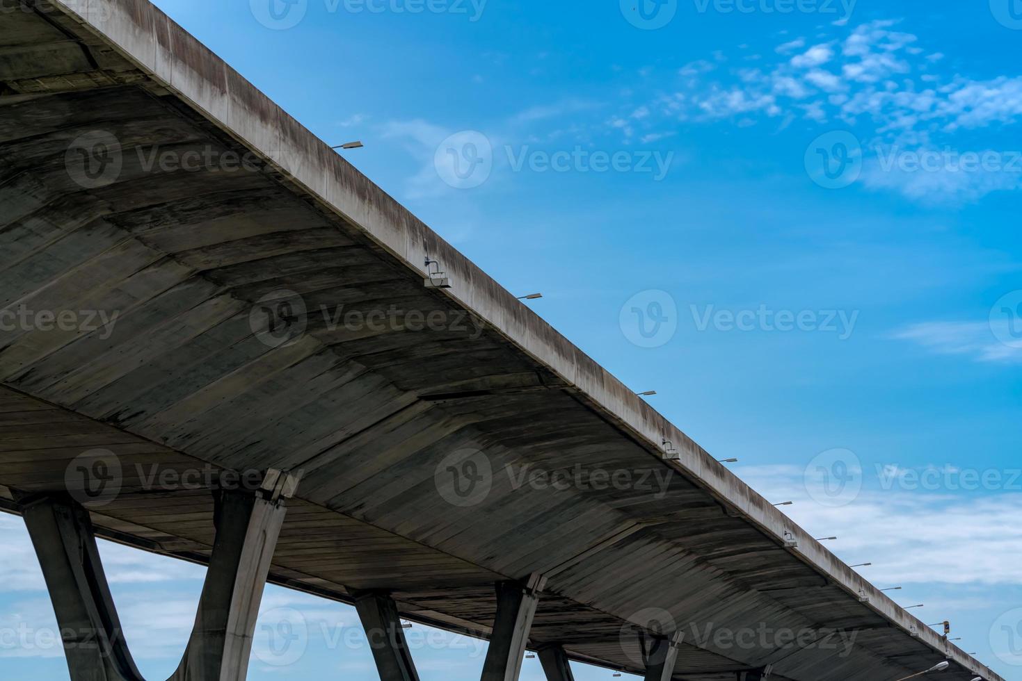 Bottom view of elevated concrete highway. Overpass concrete road. Road flyover structure. Modern motorway. Transportation infrastructure. Concrete bridge engineering construction. Bridge architecture. photo