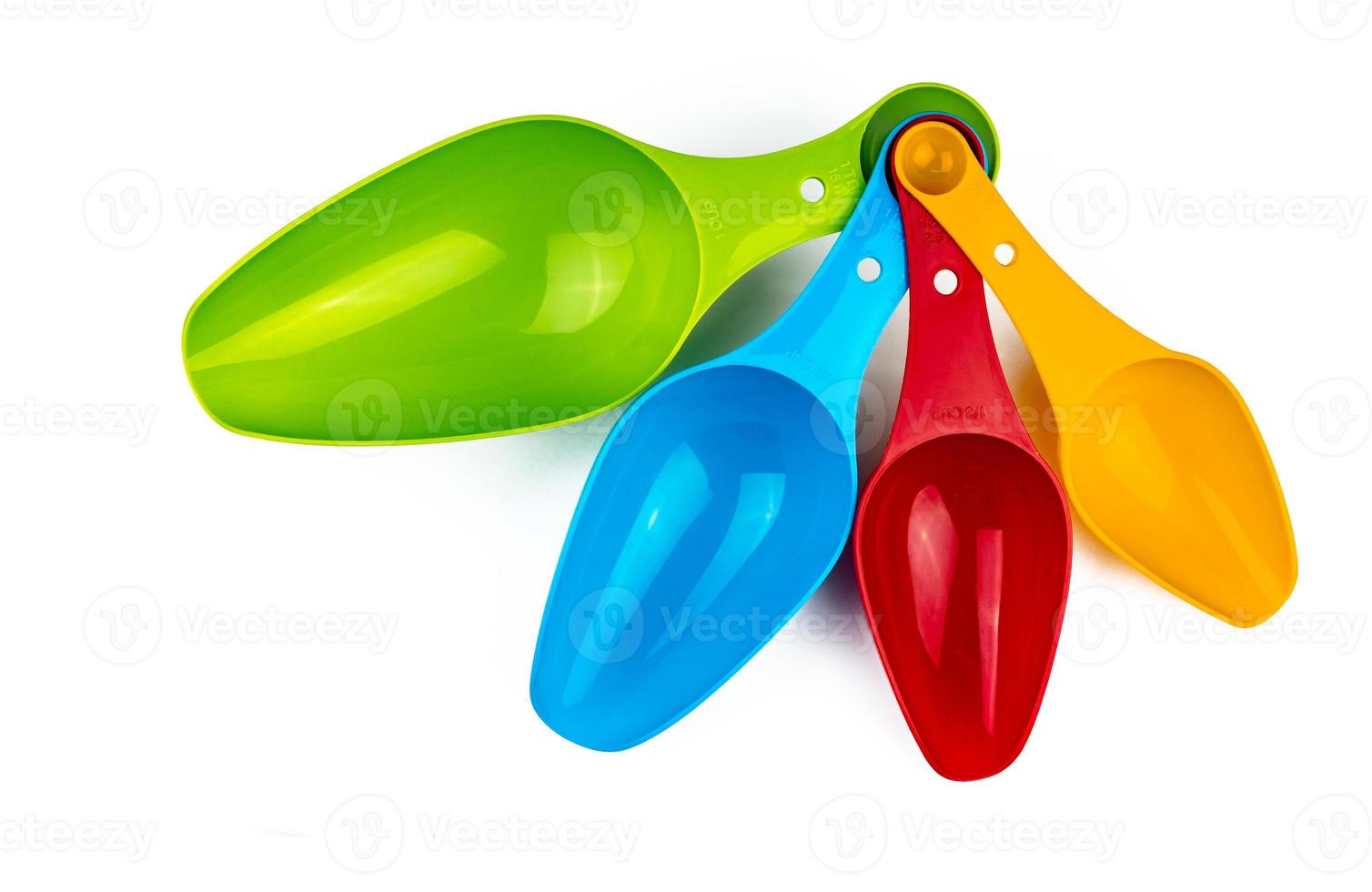 Set of colorful plastic measuring spoon isolated on white background with shadow. Green, blue, red, and orange plastic measuring spoon. photo