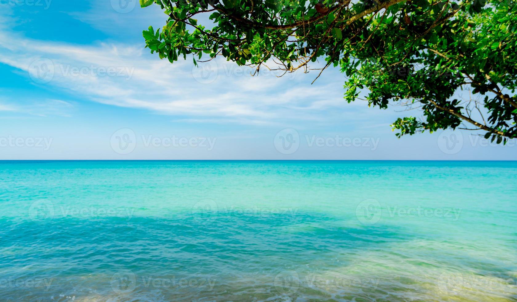 Beautiful tropical paradise beach background. Summer vibes. Summer vacation time background. Ocean waves. Calm, tranquil and relax scene. Emerald green sea water and blue sky and white clouds. Skyline photo