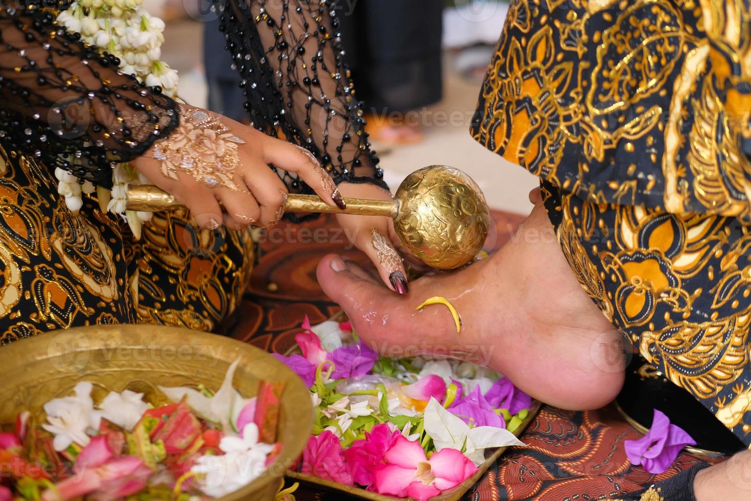 Traditional Javanese bride, the process of cleaning the husband's feet with flowers for Javanese brides photo