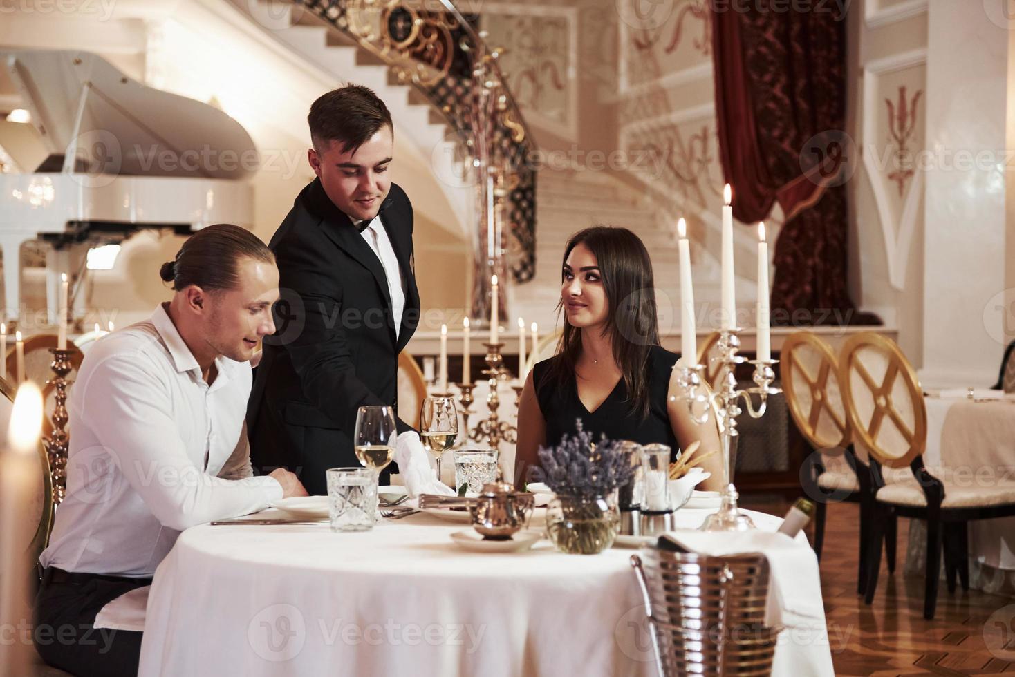 Professional service. Beautiful couple have romantic dinner in luxury restaurant at evening time photo