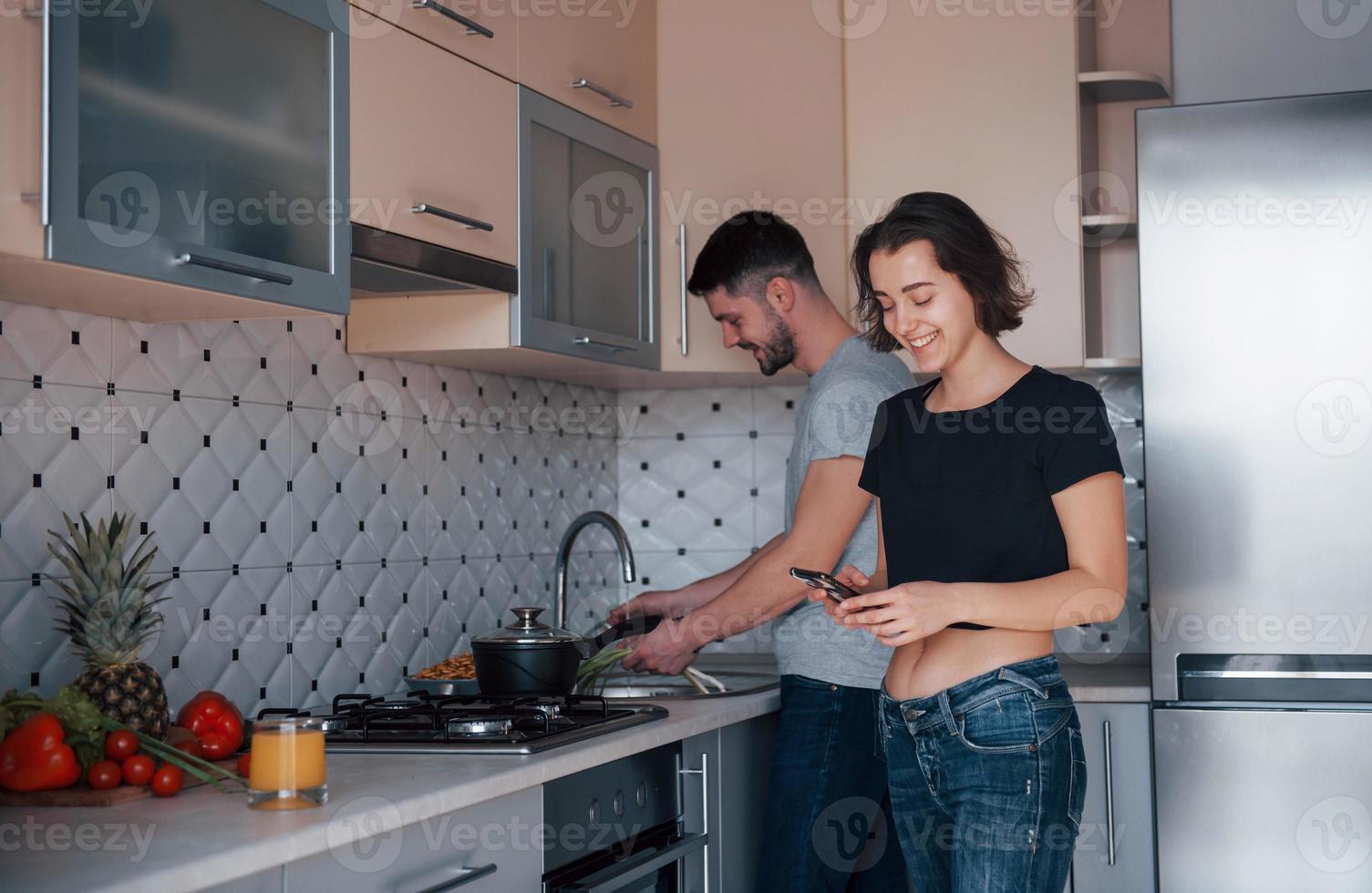 estado de ánimo alegre. pareja joven en la cocina moderna en casa en su tiempo de fin de semana en la mañana foto