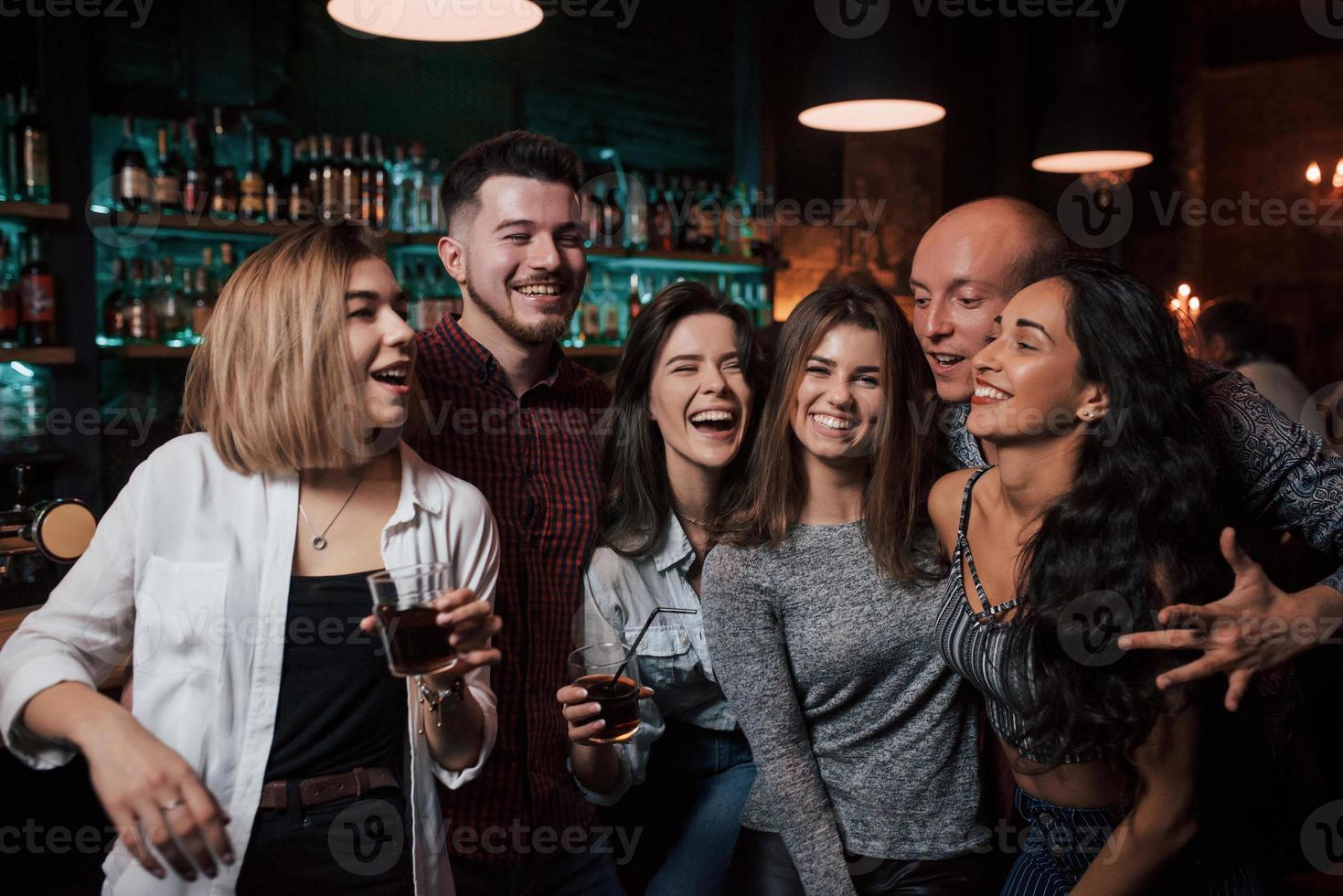 sonrisa para retrato. hermosos jóvenes tienen fiesta junto con alcohol en la discoteca foto