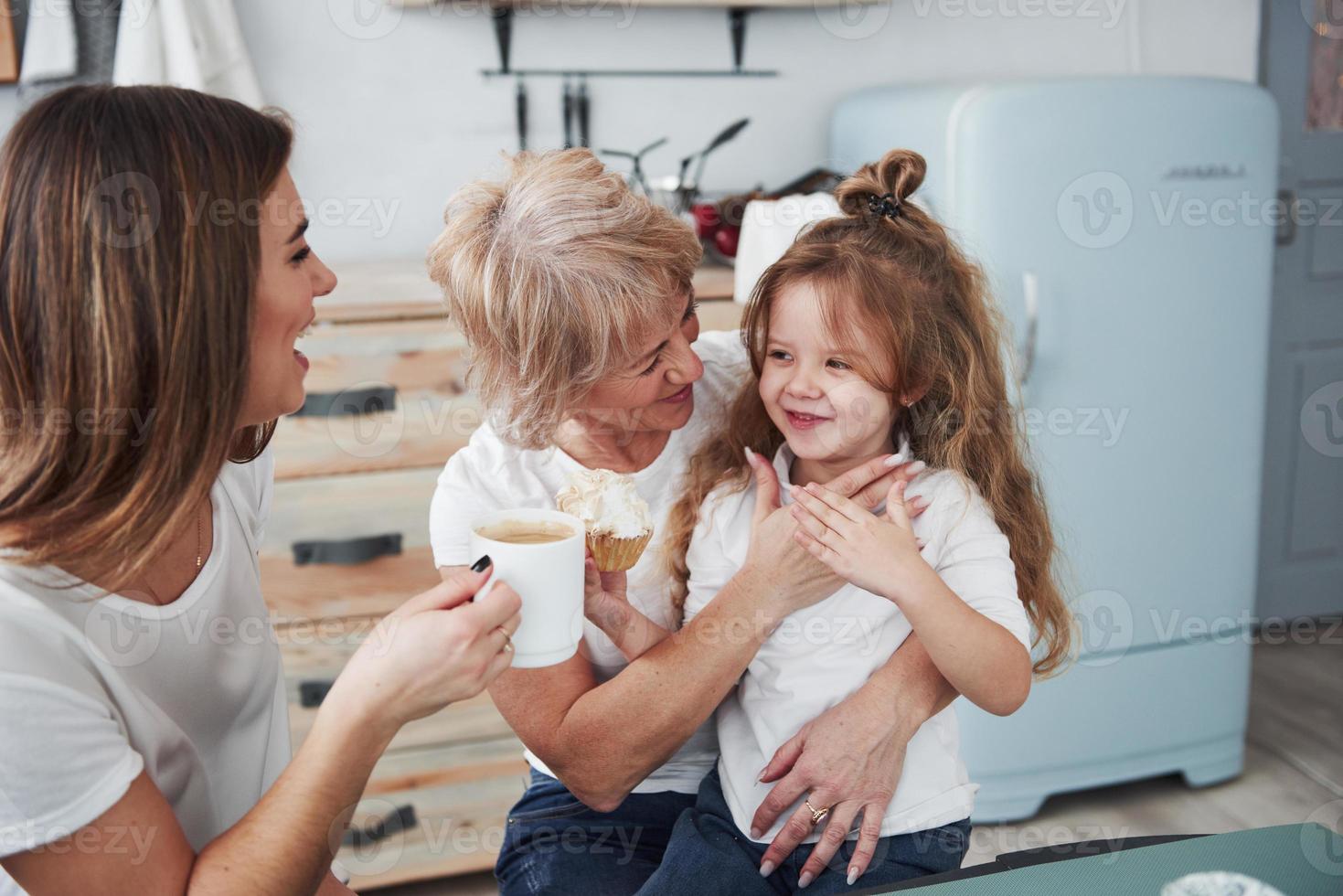 Cheerful people. Mother, grandmother and daughter having good time in the kitchen photo