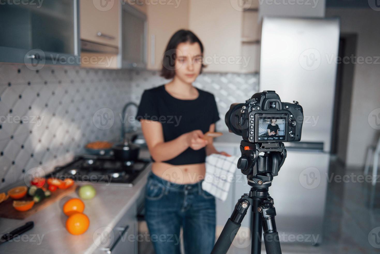 Holding wooden shovel. Girl in the modern kitchen at home at her weekend time in the morning photo