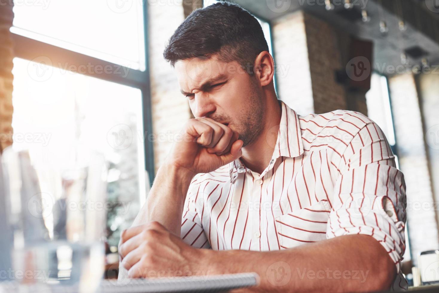 Looks like something wrong. Adult man sits in cafe at daytime and read some hard explained information photo