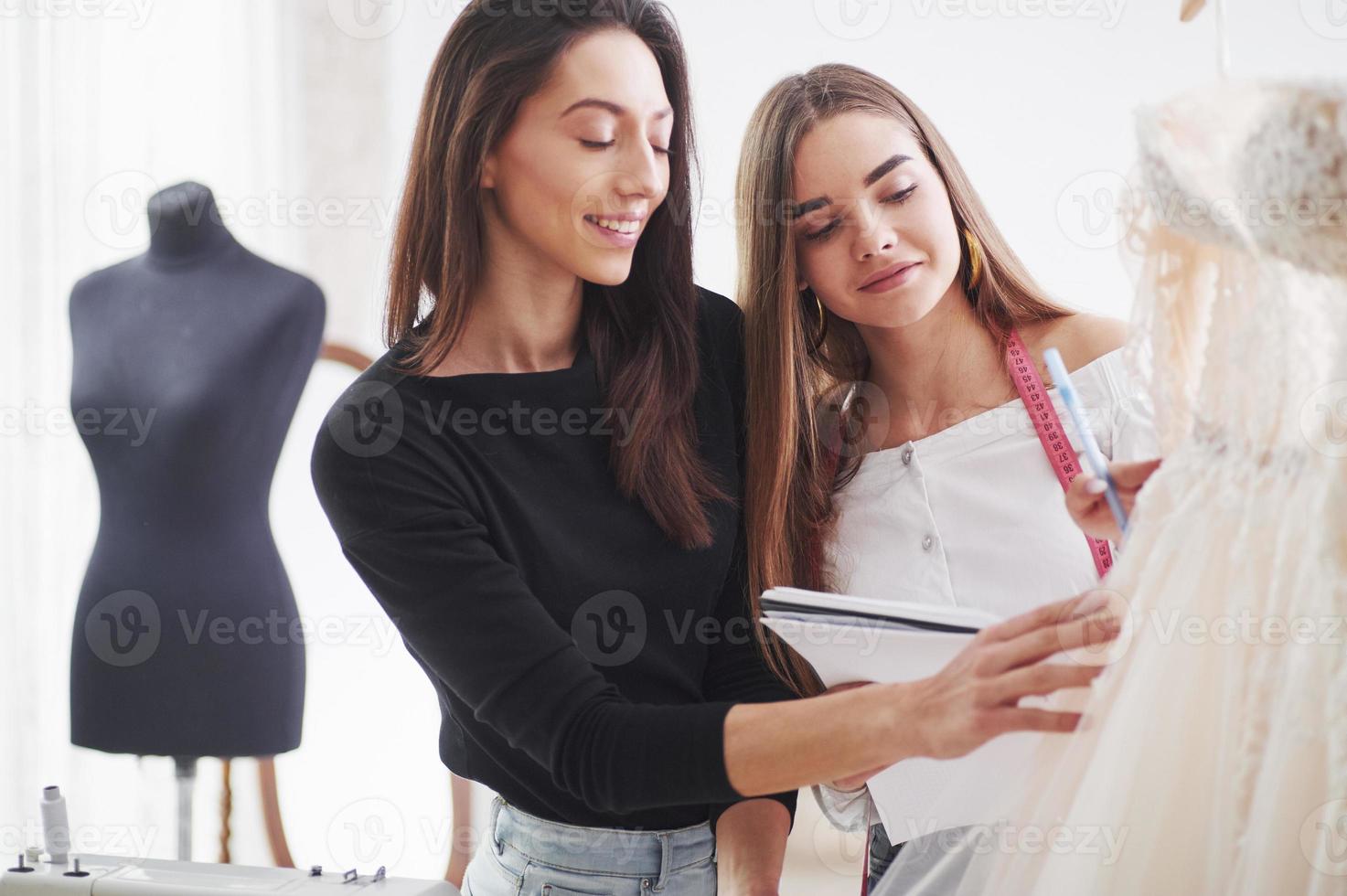 Working together. The process of fitting the dress in the studio of hand crafted clothes photo