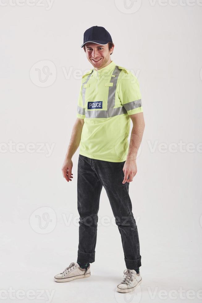 For your security. Policeman in green uniform stands against white background in the studio photo