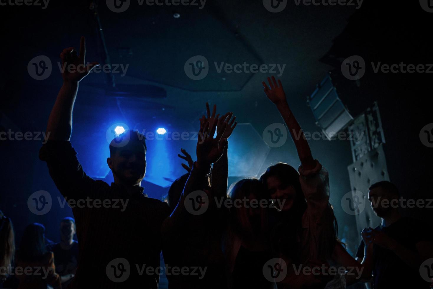 We are getting captured by cameramen. Group of people that enjoying dancing in the nightclub with beautiful lightings photo