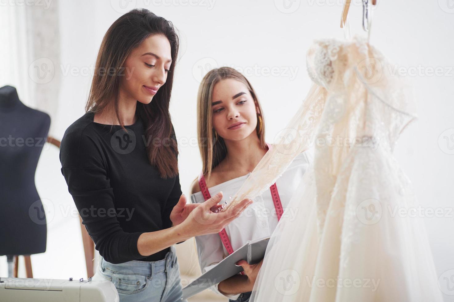 Need to check all of details to make sure that everything is perfect. The process of fitting the dress in the studio of hand crafted clothes photo