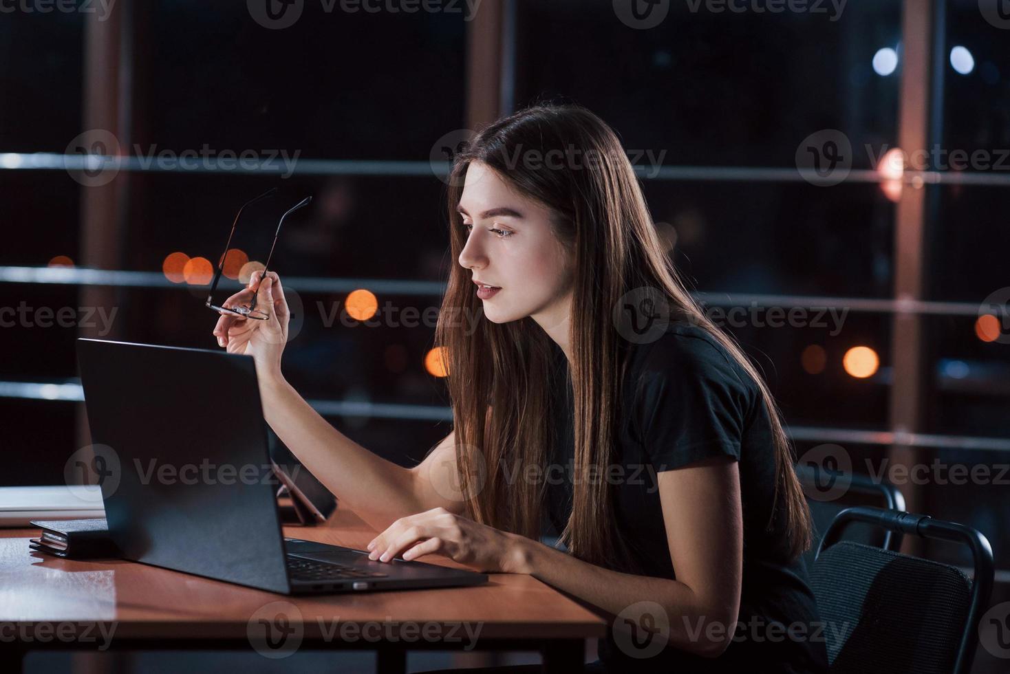 hermosa mujer de negocios rubia trabaja sola en la oficina por la noche foto