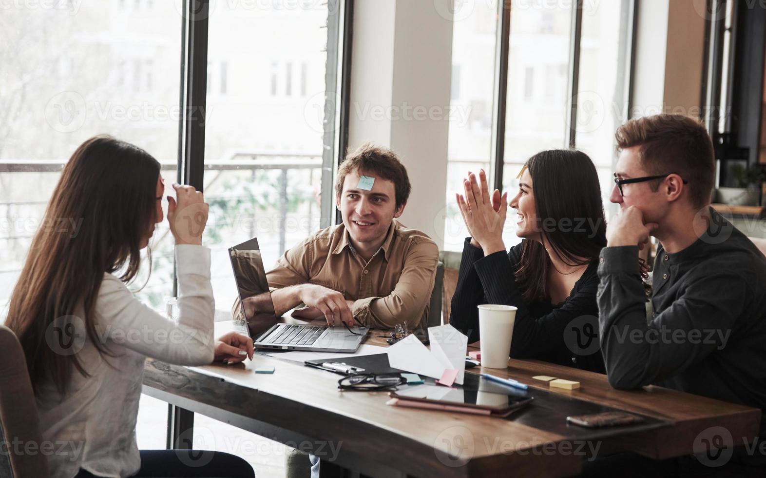 Discussing with each other. Having fun in the office room. Friendly coworkers playing around at their break time photo