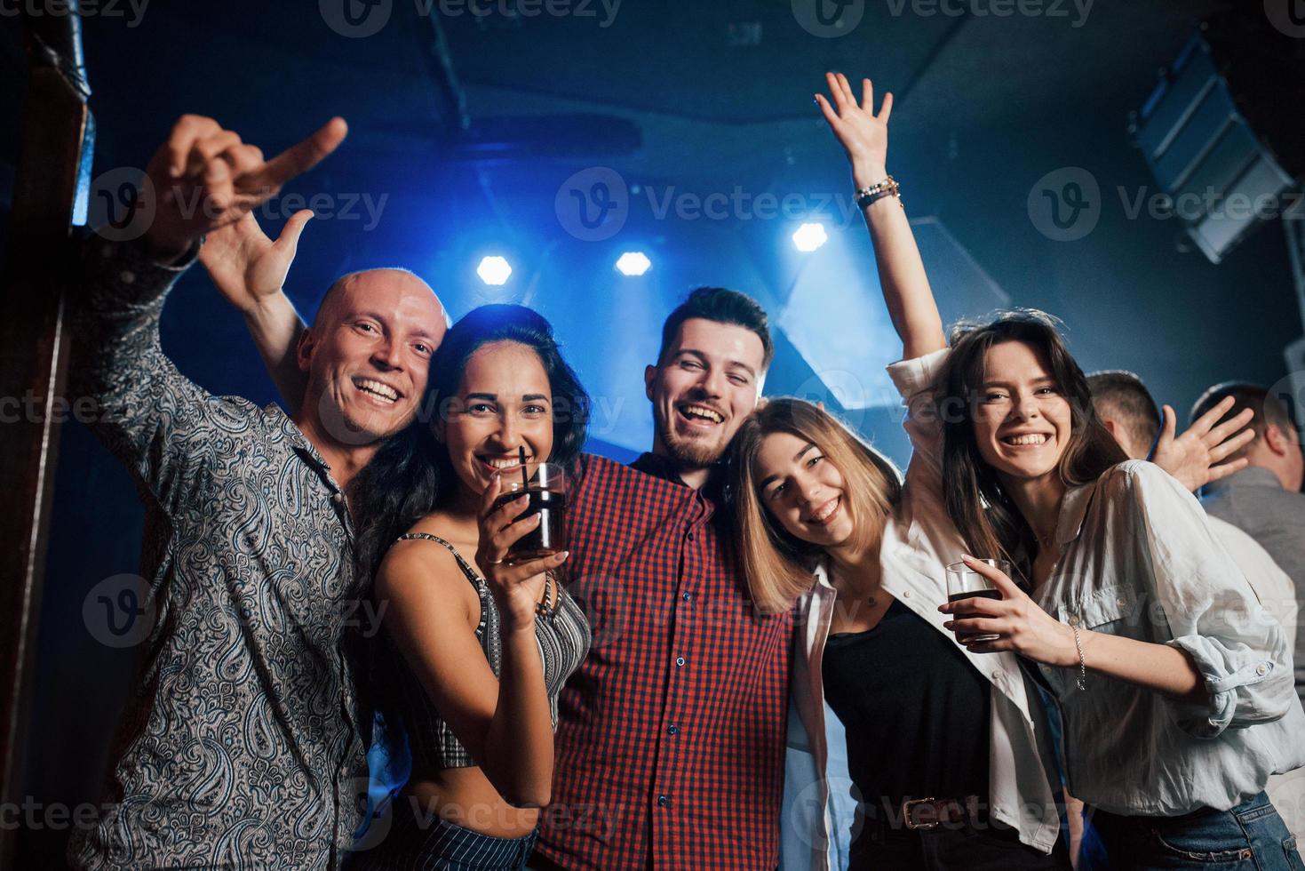 decir queso. hermosos jóvenes tienen fiesta junto con alcohol en la discoteca foto