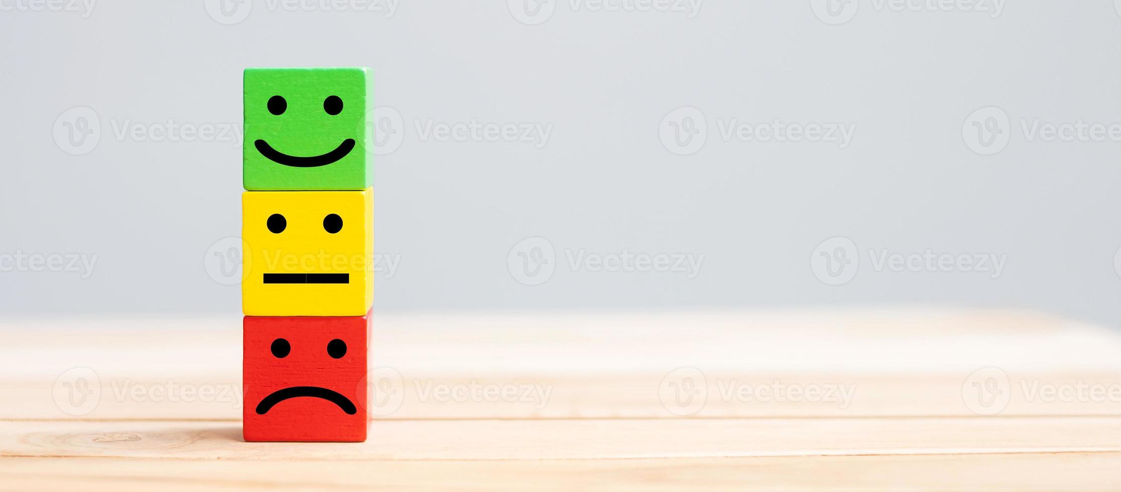 Emotion face symbol on wooden cube blocks. Service rating, ranking, customer review, satisfaction and feedback concept. photo