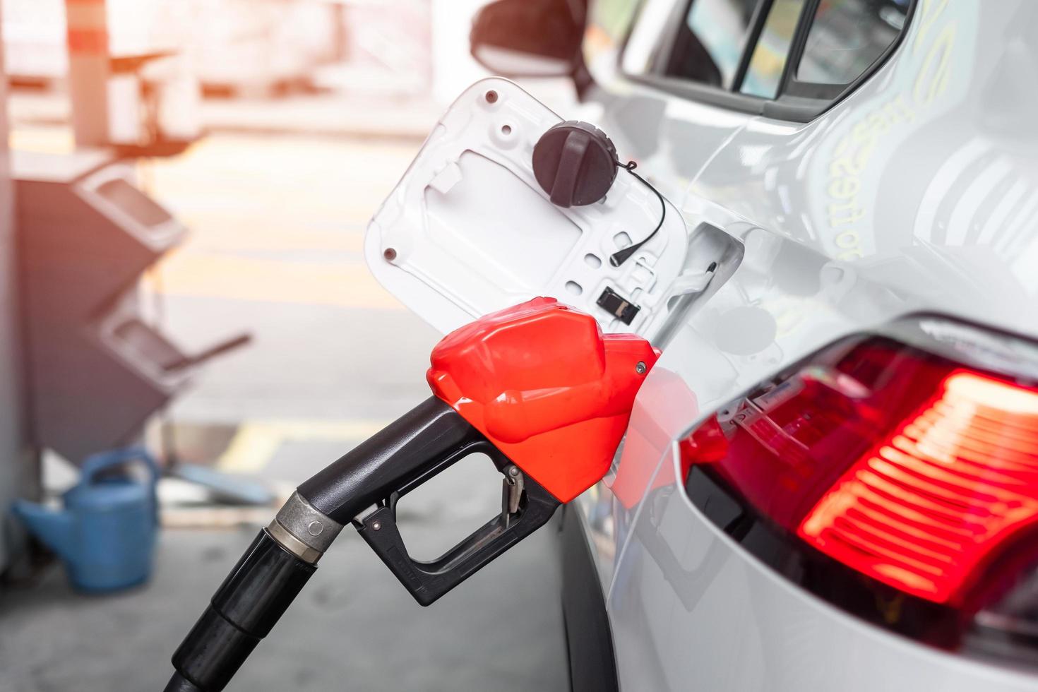 repostar en el coche, boquilla de combustible de gasolina en el vehículo en la gasolinera. precio del petróleo, economía del petróleo, inflación y concepto de productos básicos foto