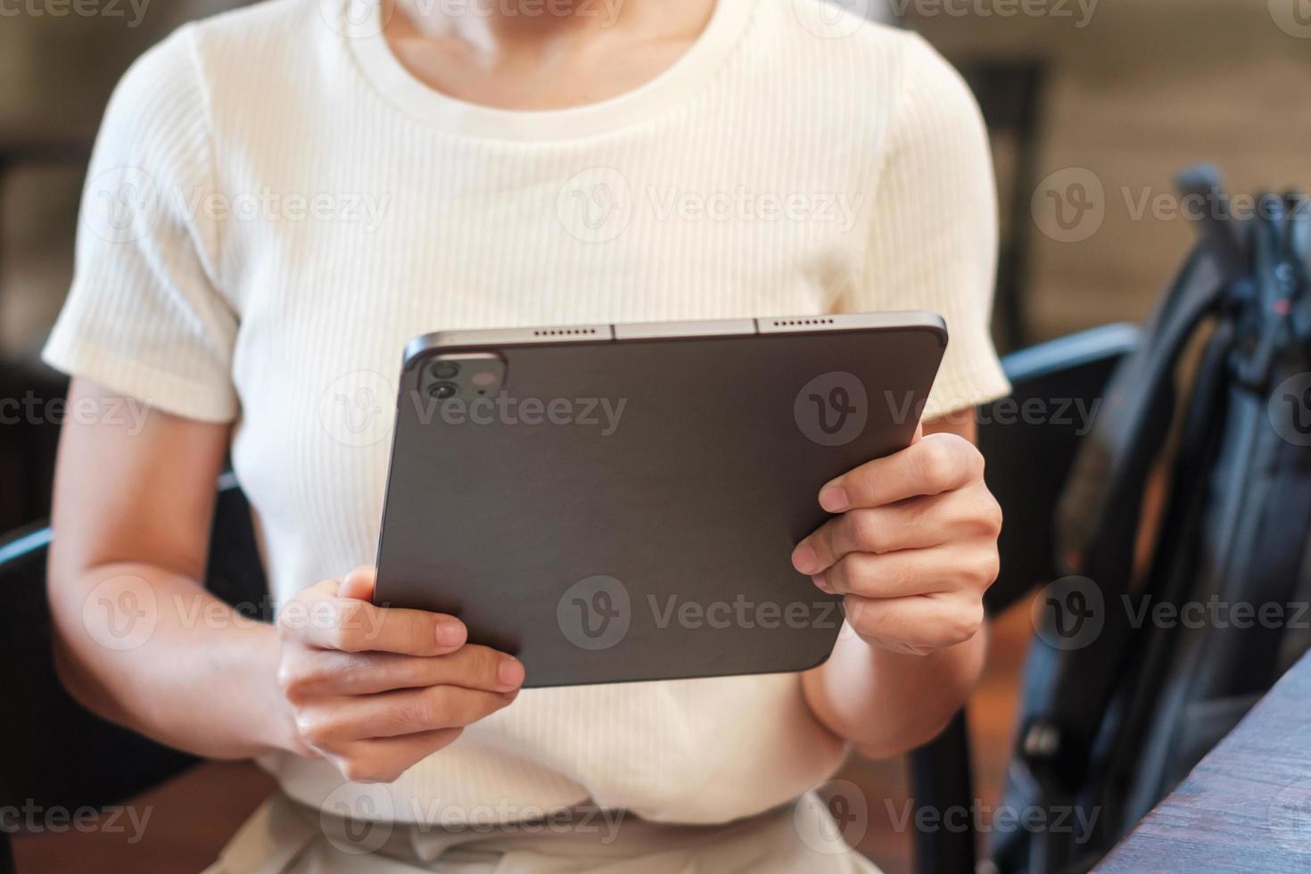 woman using tablet for sms messages, hand holding pencil typing touchscreen mobile phone in cafe or modern office. lifestyle, technology, Social media and network concept photo