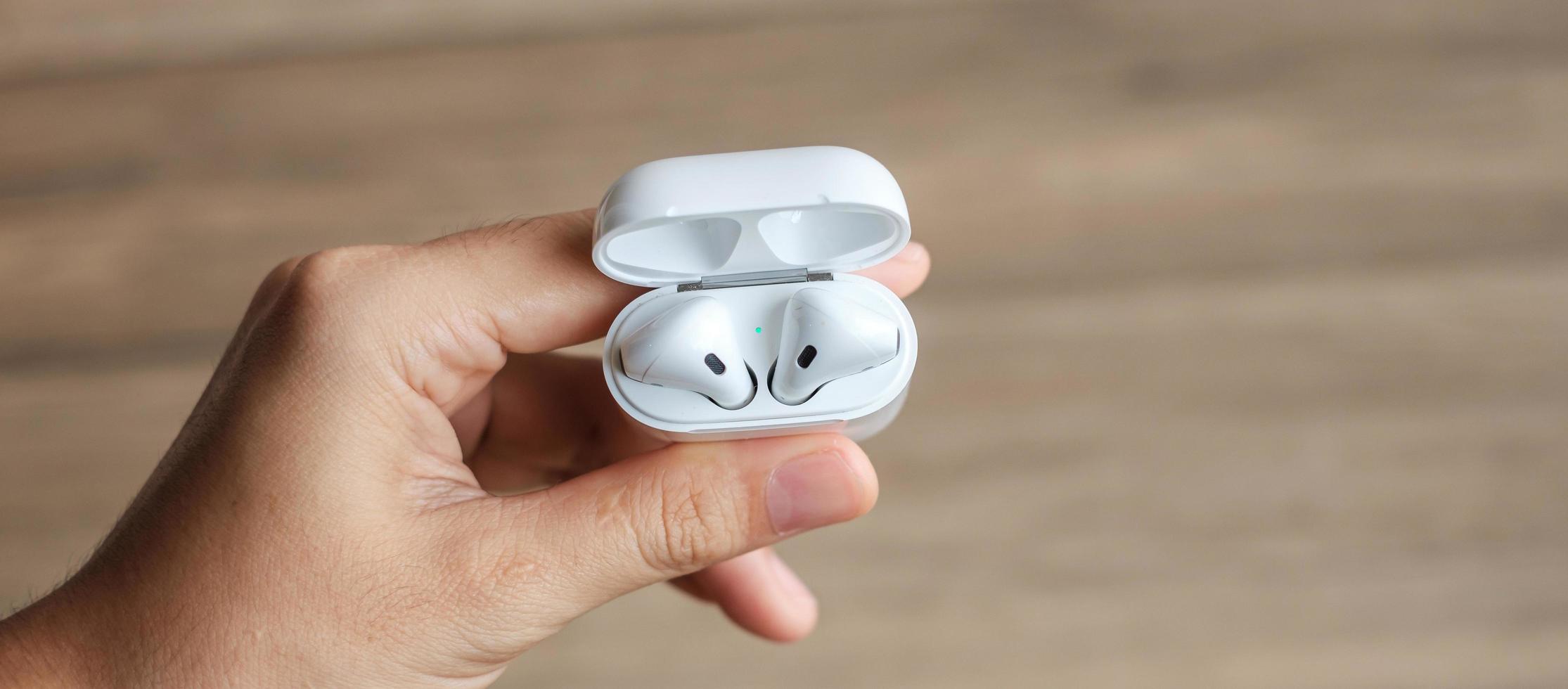 White wireless earphone or headphones on table for using with smartphone. Technology concept photo