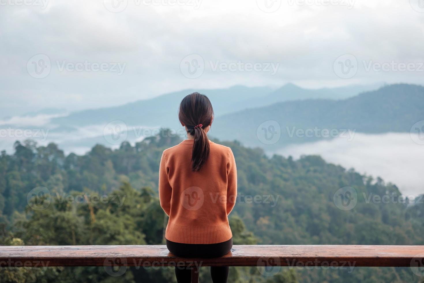 Happy woman relaxing and looking mountain view at countryside home or homestay in the morning. Vacation, blogger, SoloTravel, journey, trip and relaxing concept photo