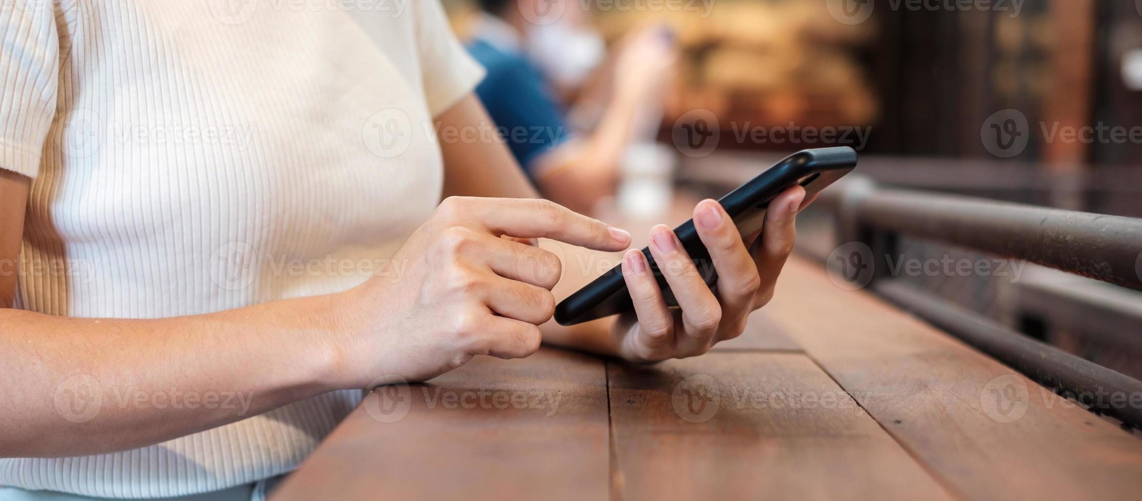 Casual Businesswoman holding and using smartphone for sms messages, young woman typing touchscreen mobile phone in cafe or modern office. lifestyle, technology, Social media and network concept photo