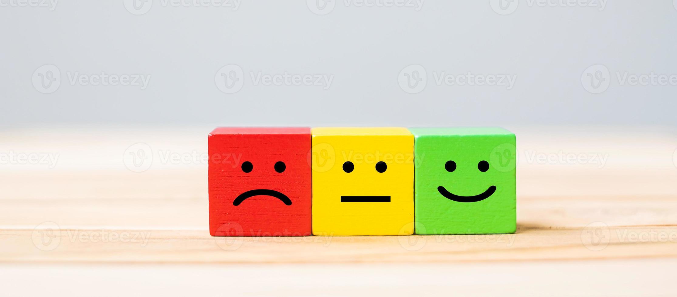 Emotion face symbol on wooden cube blocks. Service rating, ranking, customer review, satisfaction and feedback concept. photo