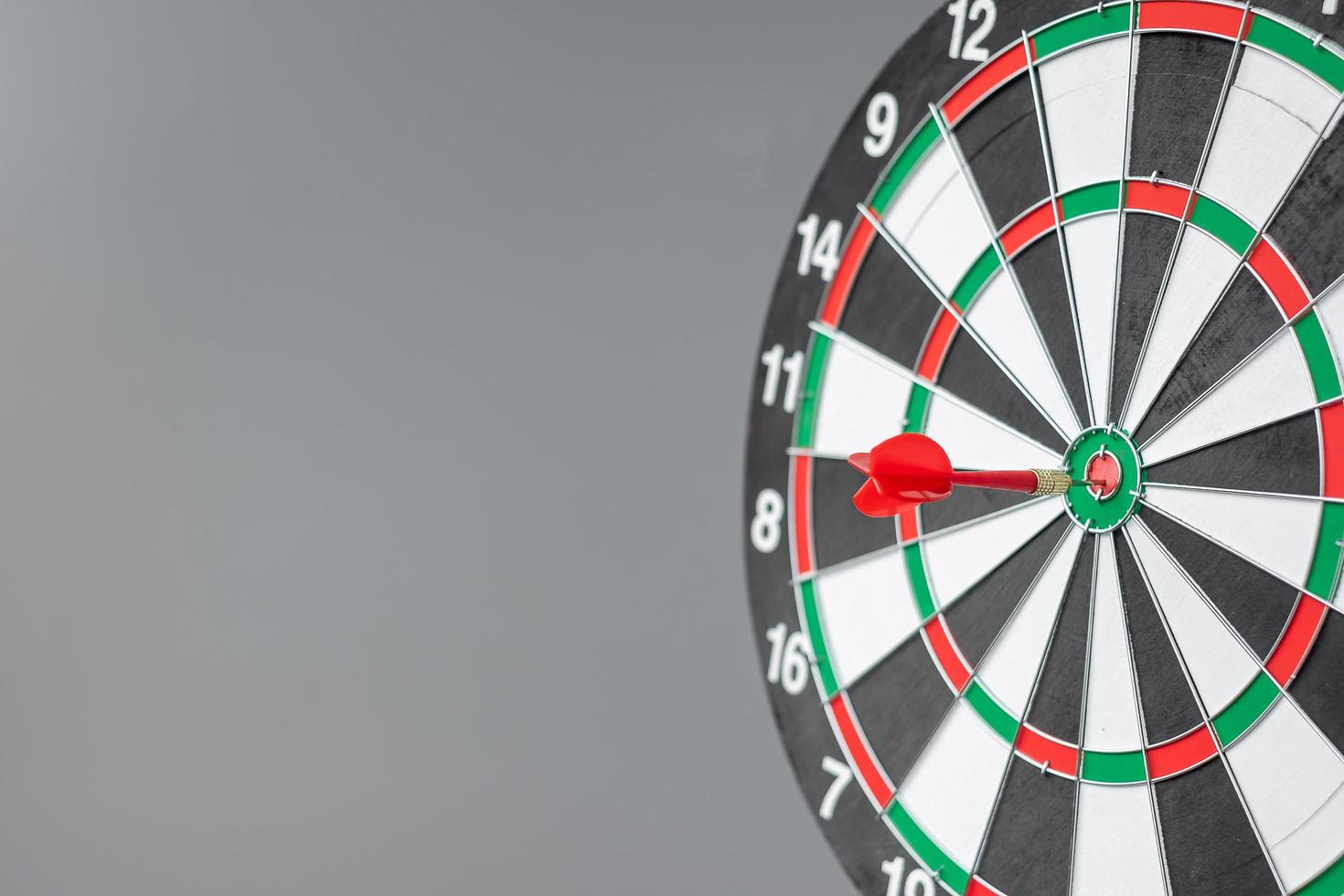 Red dart hitting a target on center of Bullseye or Dartboard. Business, competition, goal, success and marketing concept photo