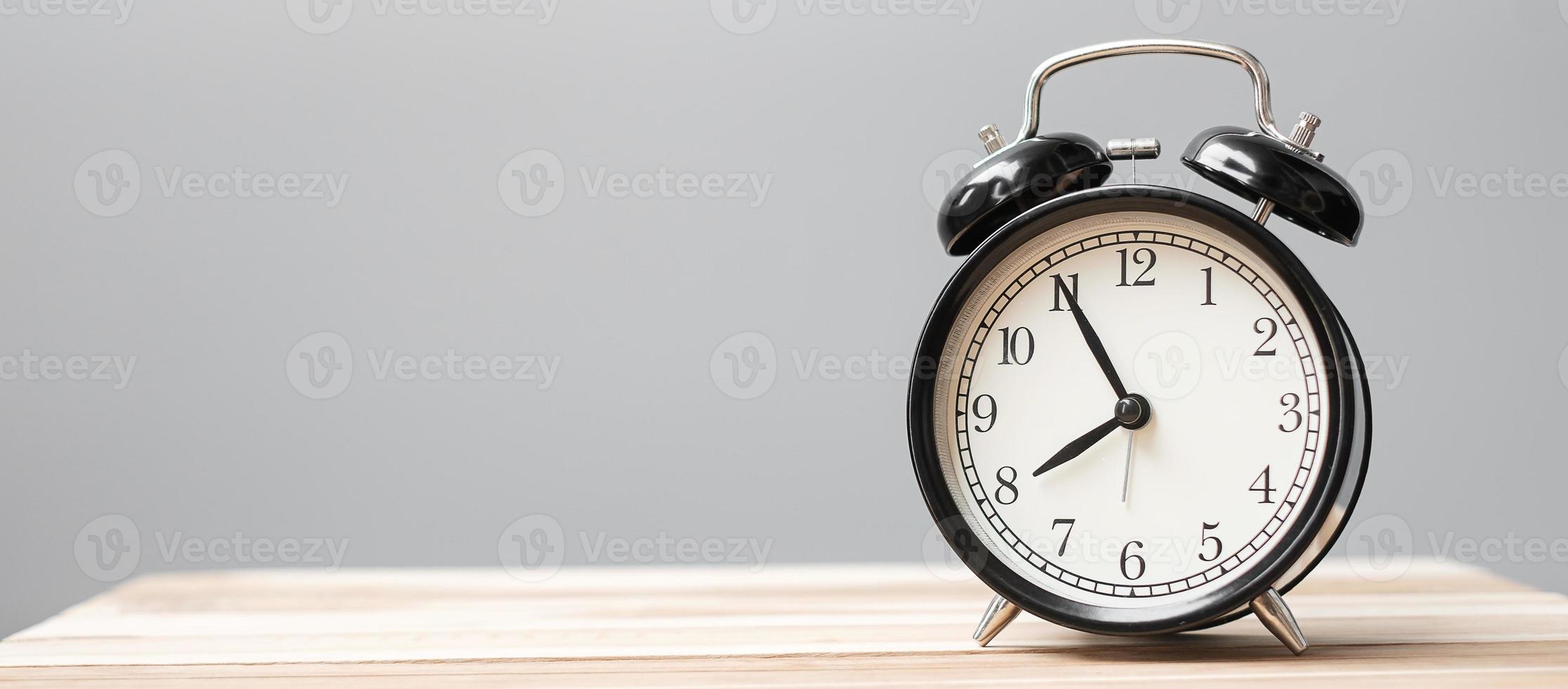 Vintage alarm clock on wooden table background and copy space for text. Activity, daily routine, morning, workout and Work life balance concept photo