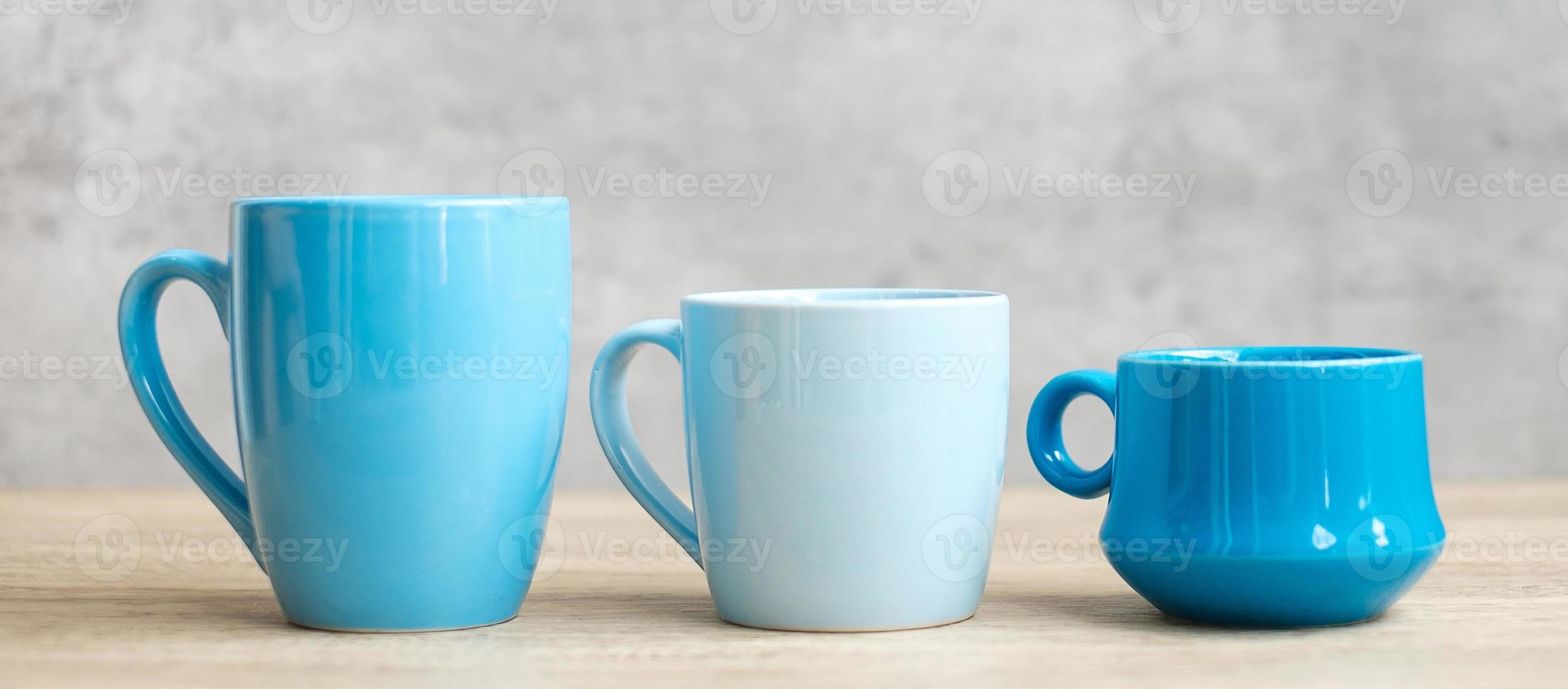 Blue coffee cup and tea mug on wood table background in the morning, Blank copy space for text. International coffee day and daily routine concept photo