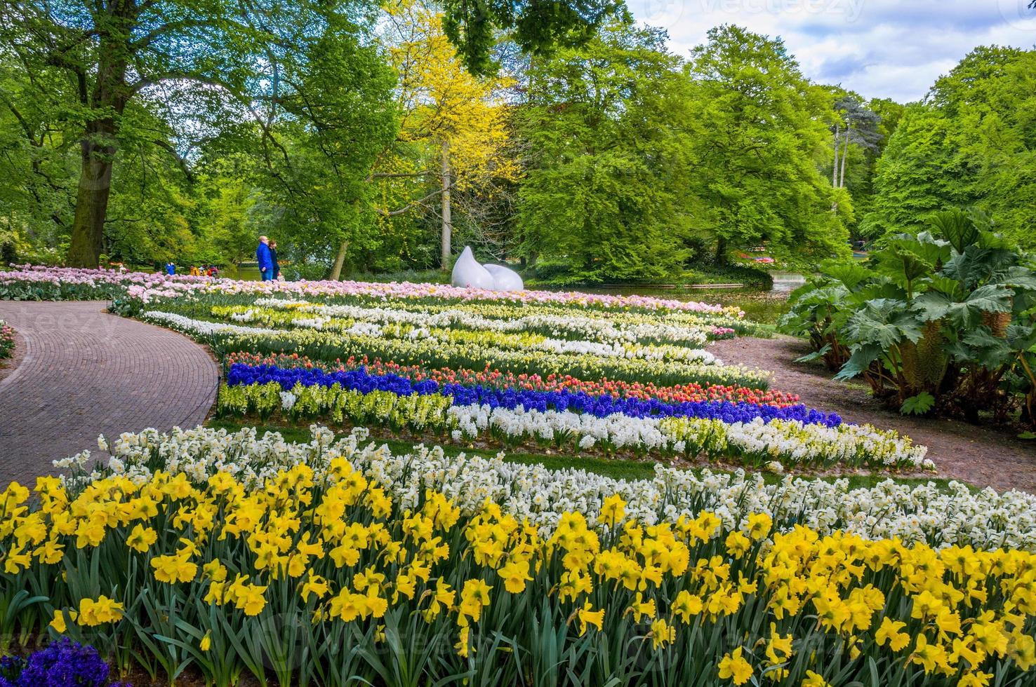 gota monumento con coloridos narcisos y tulipanes, parque keukenhof, lisse en holanda foto