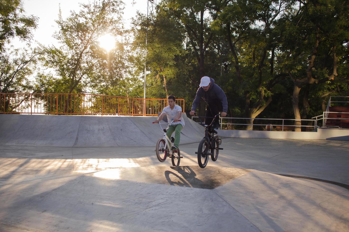 Group of young people with bmx bikes in skate plaza, stunt bicycle riders in skatepark photo