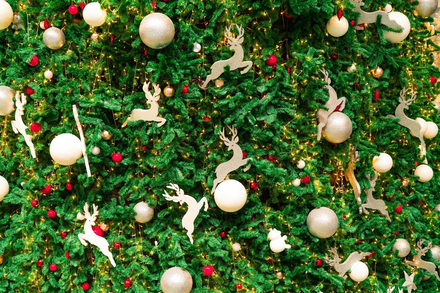 Close up Christmas tree decoration with red, gold, silver, and white balls, silver star and white reindeer. Xmas background. Christmas and Happy New Year background. Colorful ball on Christmas tree. photo
