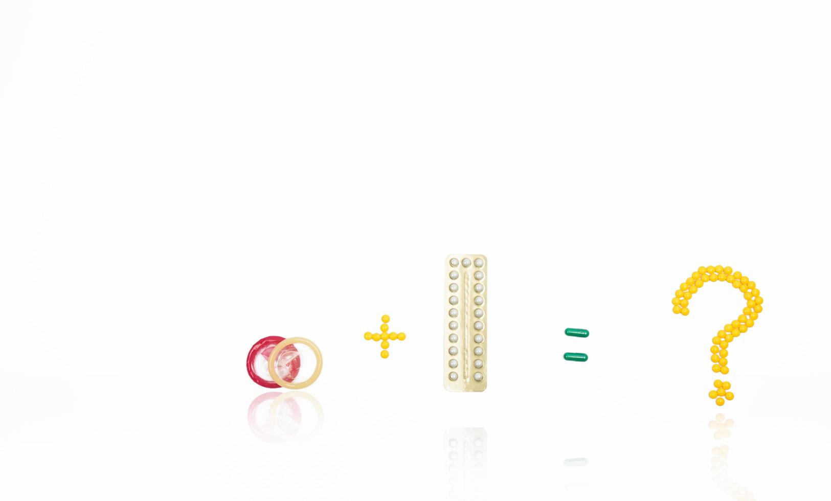 Condoms and contraceptive pills with question mark, equal, plus sign. Family planning in teenage and adult concept. Prevention of unintended pregnancy photo
