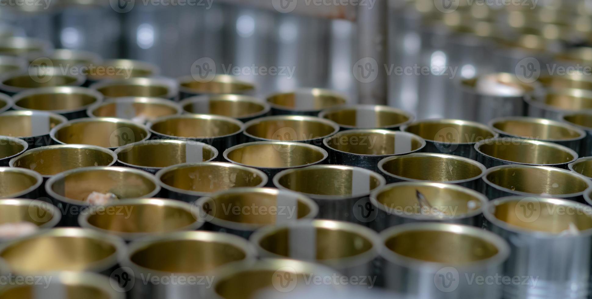 Canned fish factory. Food industry.  Many can of sardines on a conveyor belt. Sardines in red tomato sauce in tinned cans at food factory. Food processing production line. Food manufacturing industry. photo
