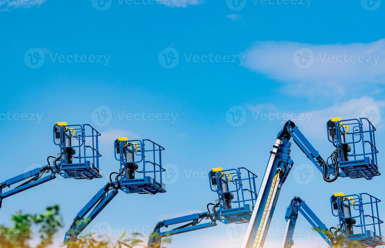 Articulated boom lift. Aerial platform lift. Telescopic boom lift against blue sky. Mobile construction crane for rent and sale. Maintenance and repair hydraulic boom lift service. Crane dealership. photo