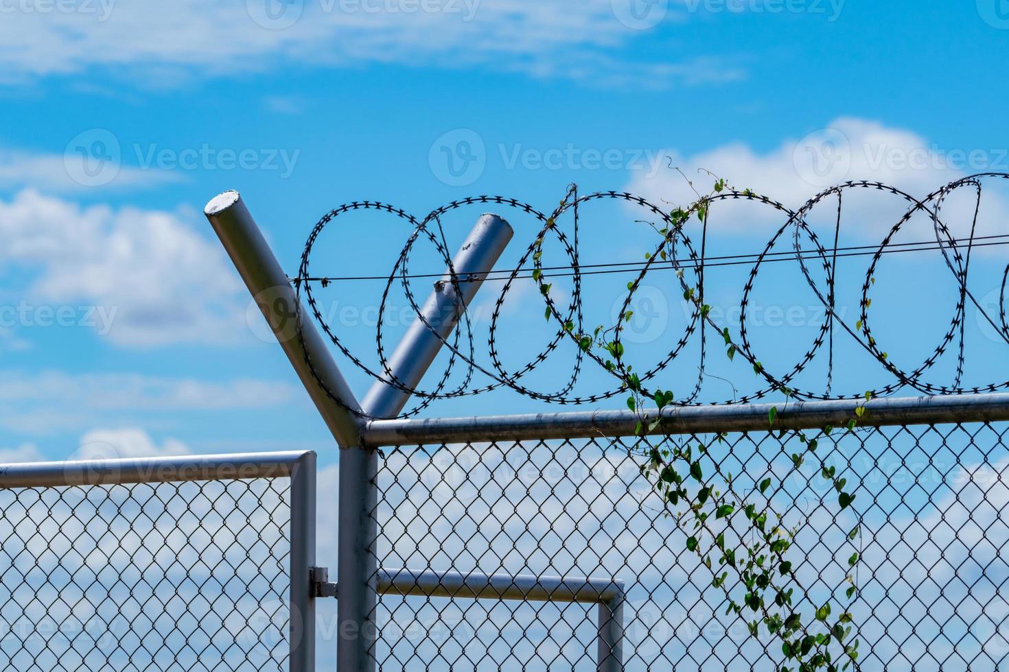 Prison security fence. Barbed wire security fence. Razor wire jail fence. Barrier border. Boundary security wall. Prison for arrest criminals or terrorists. Private area. Military zone concept. photo