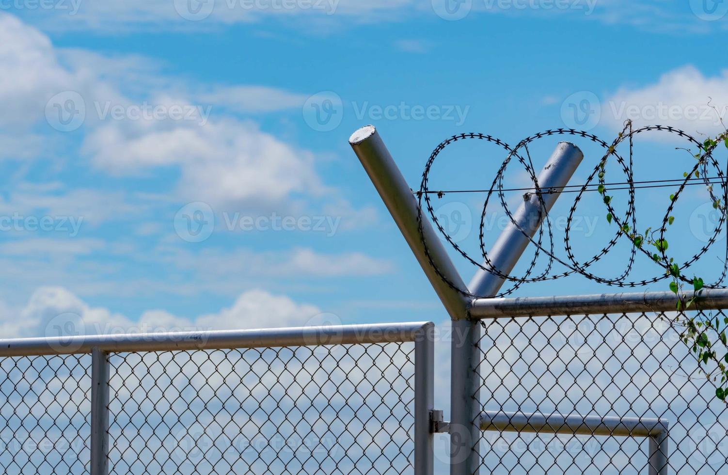 Prison security fence. Barbed wire security fence. Razor wire jail fence. Barrier border. Boundary security wall. Prison for arrest criminals or terrorists. Private area. Military zone concept. photo