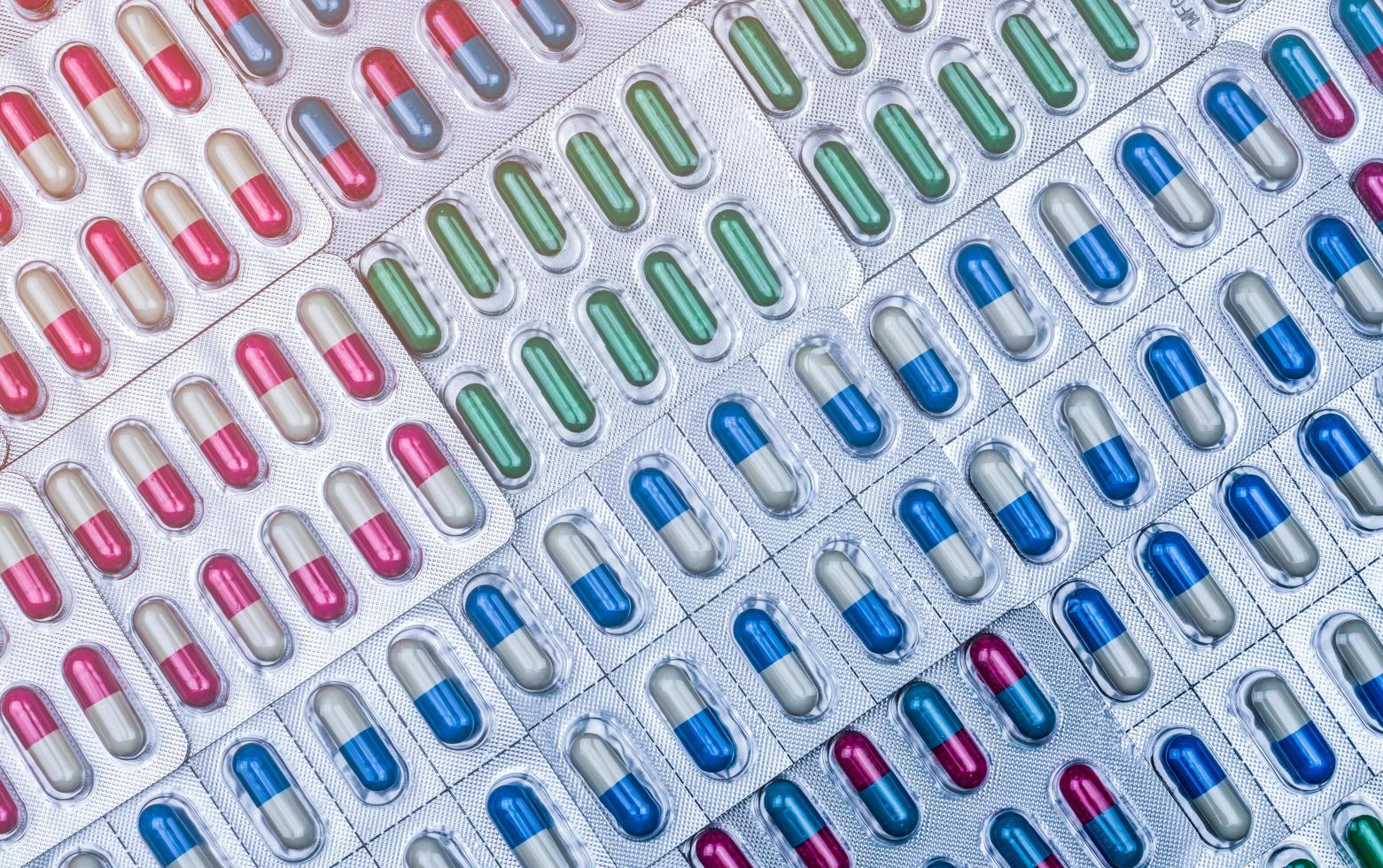 Full frame of colorful capsule pills in blister pack arranged with beautiful pattern. Pharmaceutical packaging. Medicine for infections disease. Antibiotic drug use with reasonable. Drug resistance. photo