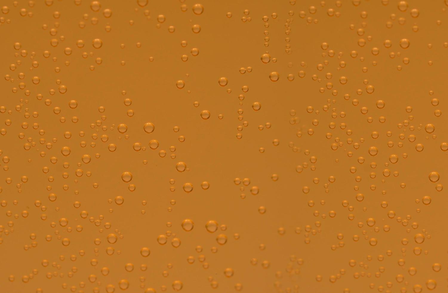 Macro shot of orange effervescent bubbles of calcium and vitamin C effervescent tablets in transparent glass photo