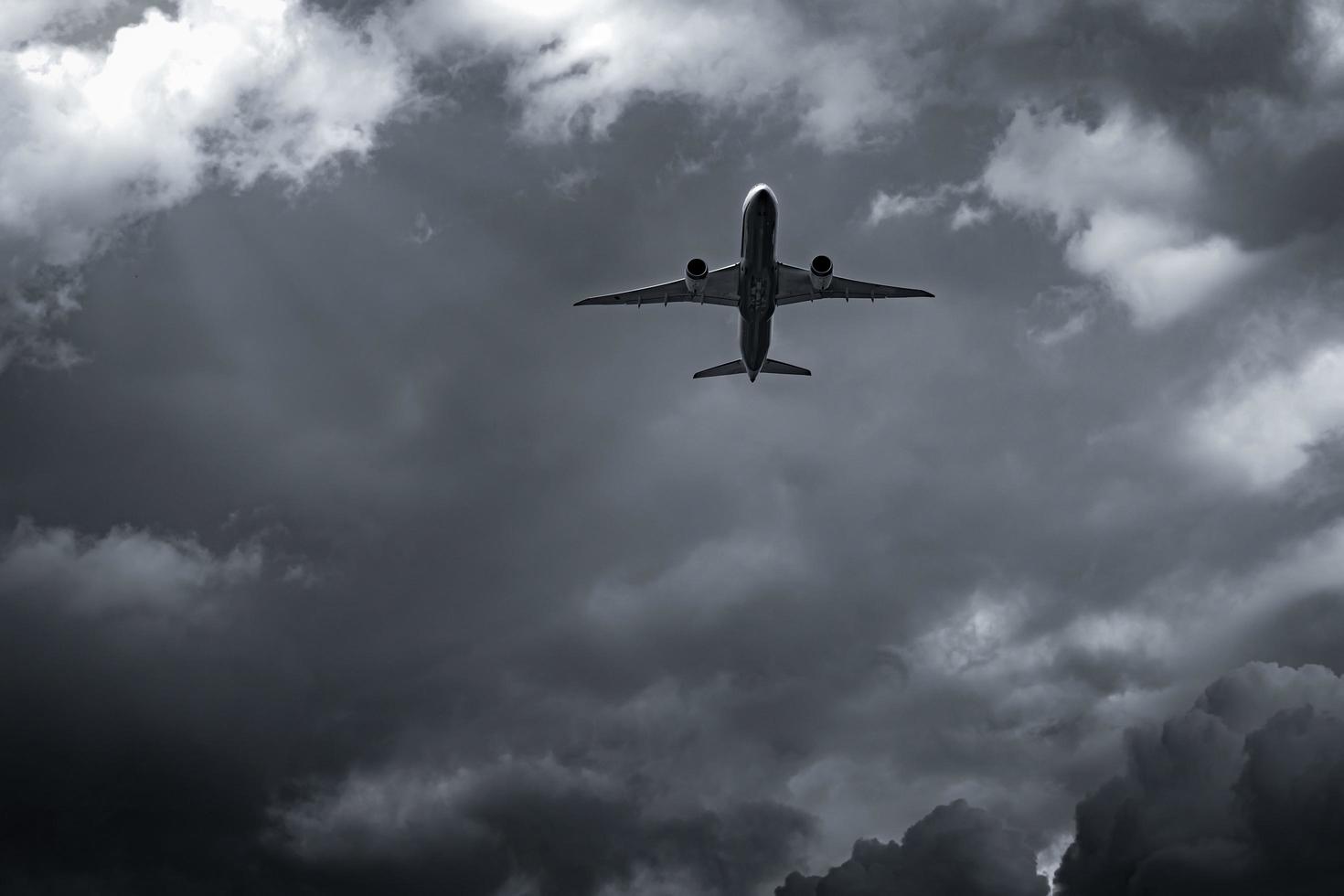 Airplane flying on dark sky and white clouds. Commercial airline with dream destinations concept. Aviation business crisis concept. Failed journey vacation flight. Air transportation. Sad travel. photo