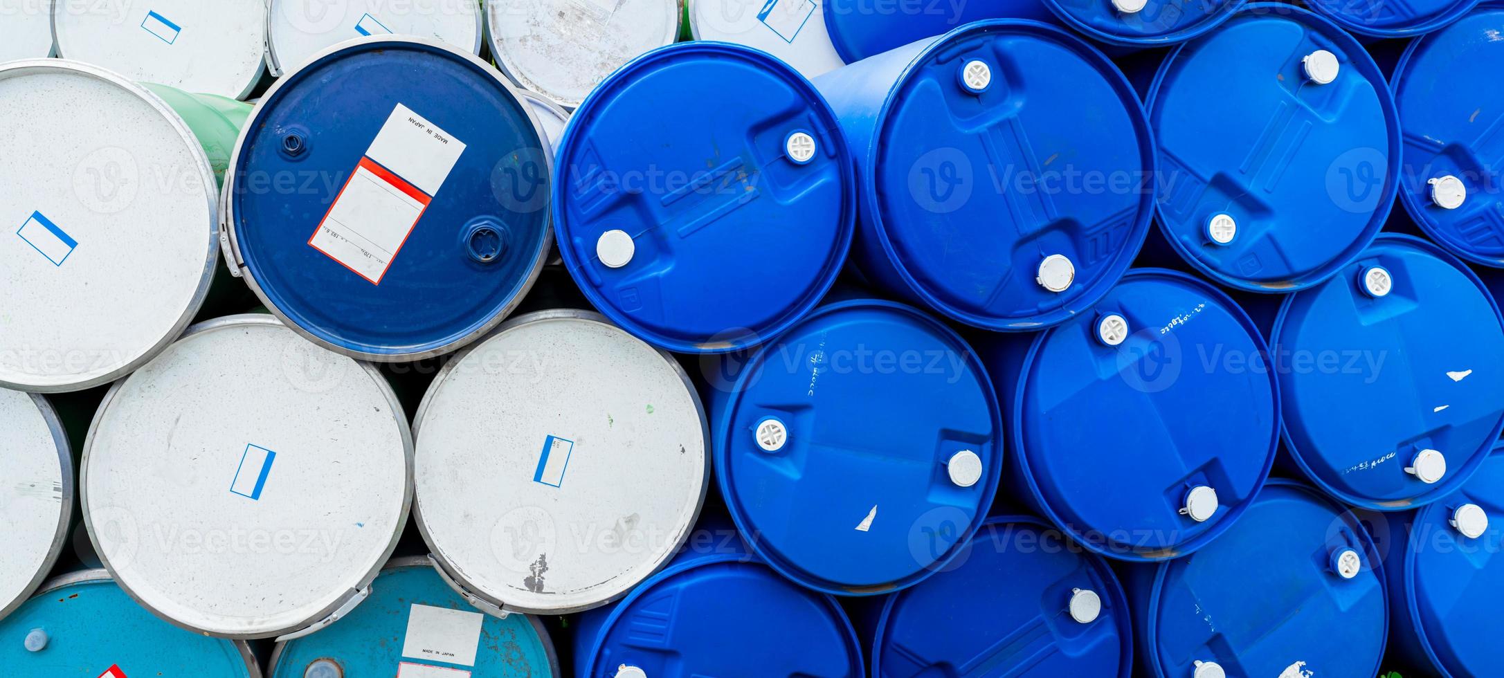 Old chemical barrels. Blue and green oil drum. Steel and plastic oil tank. Toxic waste warehouse. Hazard chemical barrel with warning label. Industrial waste in drum. Hazard waste storage in factory. photo