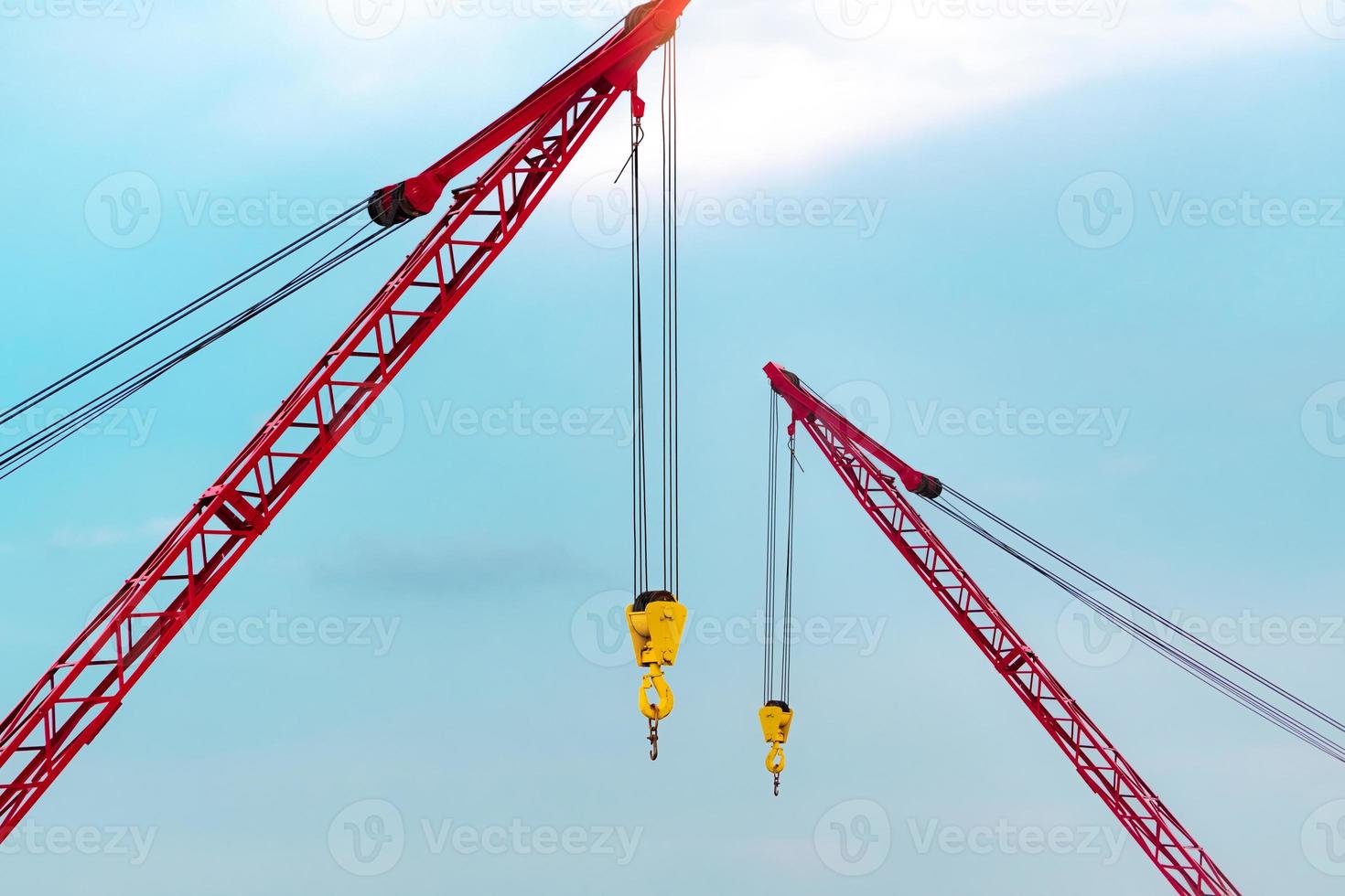 Crawler crane against blue sky and white clouds. Real estate industry. Red crawler crane use reel lift up equipment in construction site. Crane for rent. Crane dealership for construction business. photo