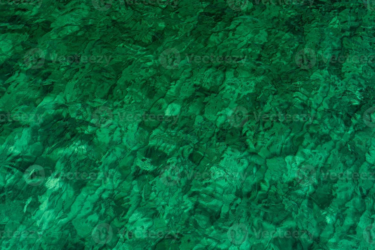 Fondo de textura abstracta verde de agua de mar verde esmeralda. vista superior del agua de mar verde con un patrón único. fondo verde superficie de onda de agua de mar en la costa. agua turquesa en mar poco profundo. foto