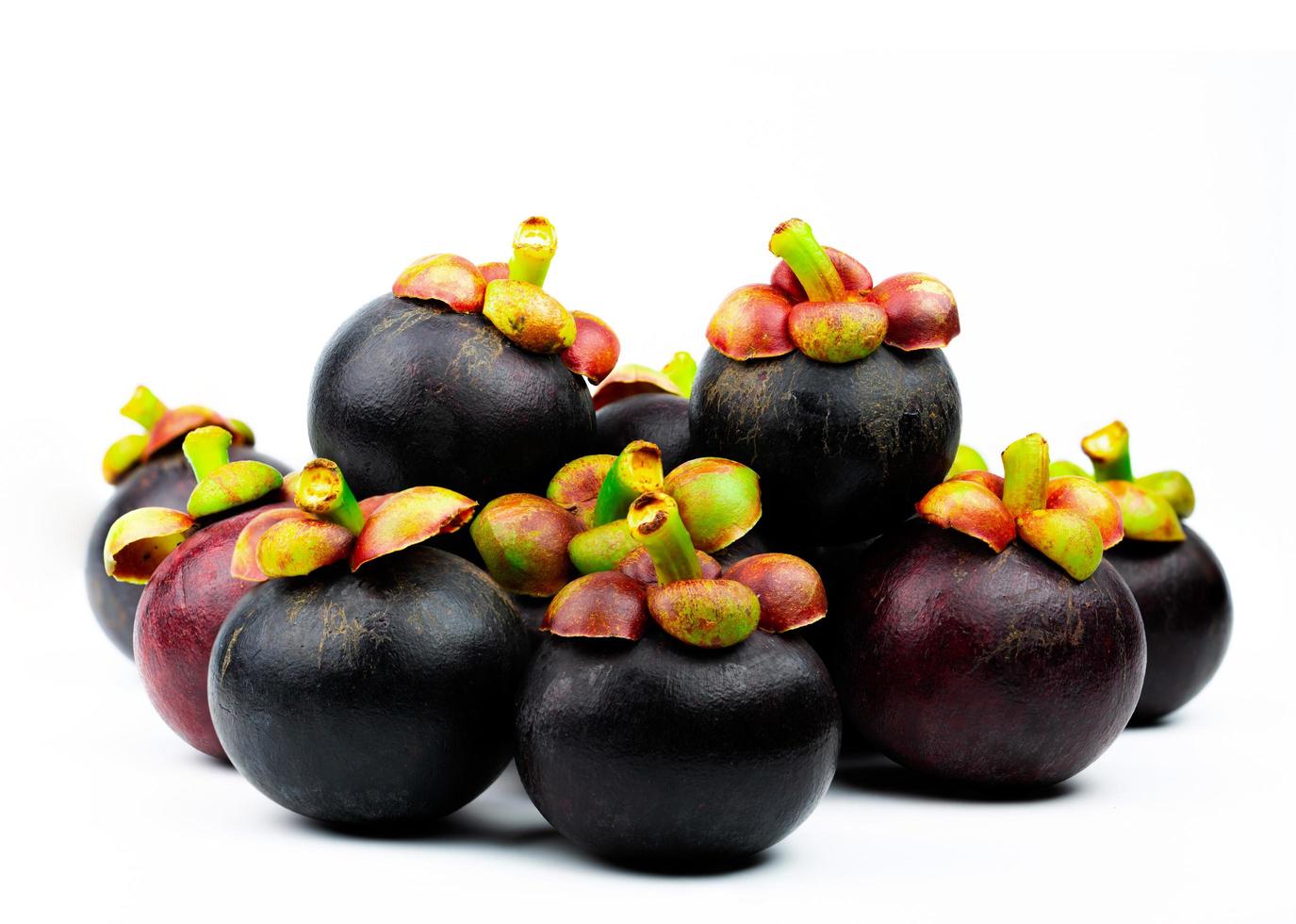 Whole mangosteen showing purple skin isolated on white background with space. Tropical fruit from Thailand. The queen of fruits. Asia fresh fruit market concept. Natural source of tannin and xanthones photo