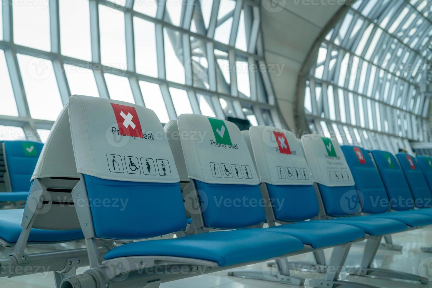 Empty seat in departure lounge at airport terminal. Distance for one seat keep distance to protect coronavirus and passenger social distancing for safety. Priority seating for people with disabilities photo