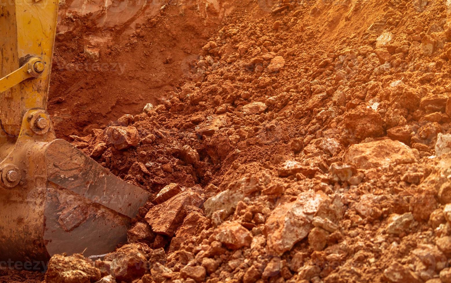 Backhoe bucket digging the soil at agriculture farm to make pond. Crawler excavator digging at shale layer. Excavating machine. Earth moving equipment. Excavation vehicle. Construction business. photo