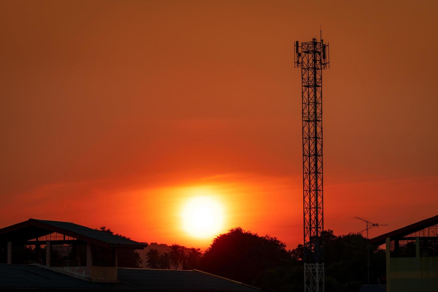 Beautiful red and orange sunset sky. Silhouette telecommunication tower in the evening with beautiful red sunset sky and clouds. Nature background. Red sunset sky in summer. Tropical summer sky. photo