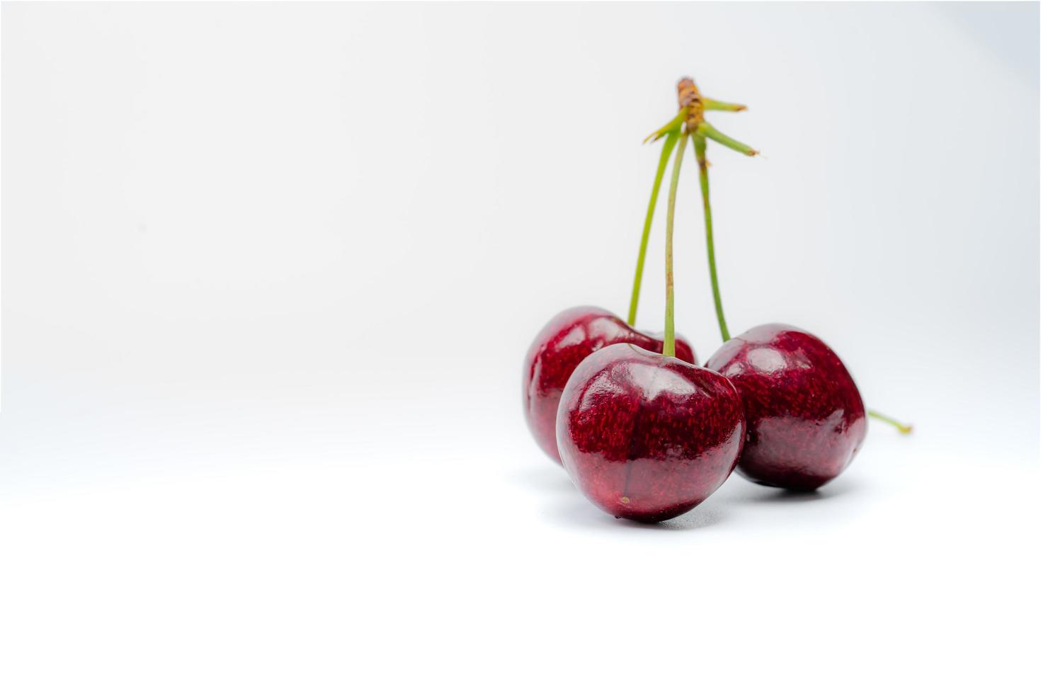 Red cherry with stalk isolated on white background. Ripe red sweet cherry. Sweet and juicy organic cherry. Fresh fruit for summer dessert. Antioxidant food. Healthy snack. photo