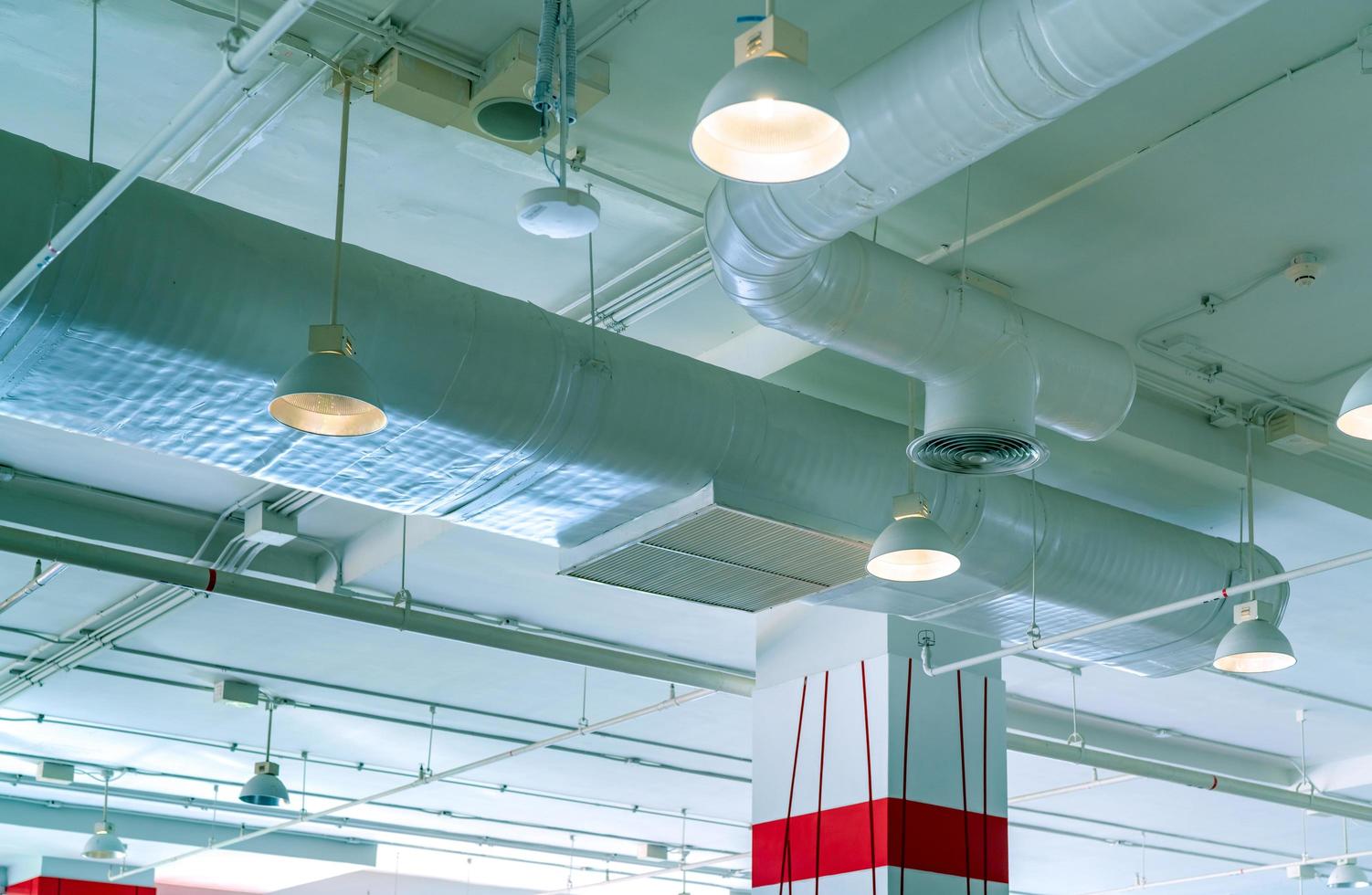 conducto de aire, sistema de ventilación de aire en el edificio del centro comercial. tubería de aire acondicionado y tubería de plomería. Plafón de luz con luz abierta. concepto interior del edificio. concepto de arquitectura de interiores. foto