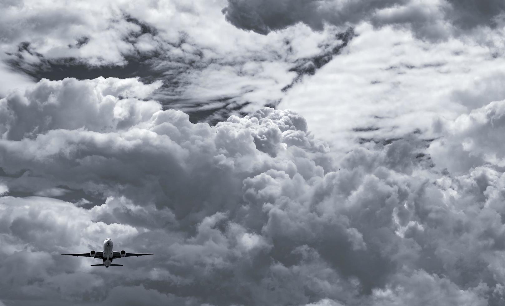 Airplane flying on dark sky and white fluffy cloud. Commercial airline with dream destinations concept. Aviation business crisis concept. Failed summer vacation flight. Air transportation. Sad travel. photo